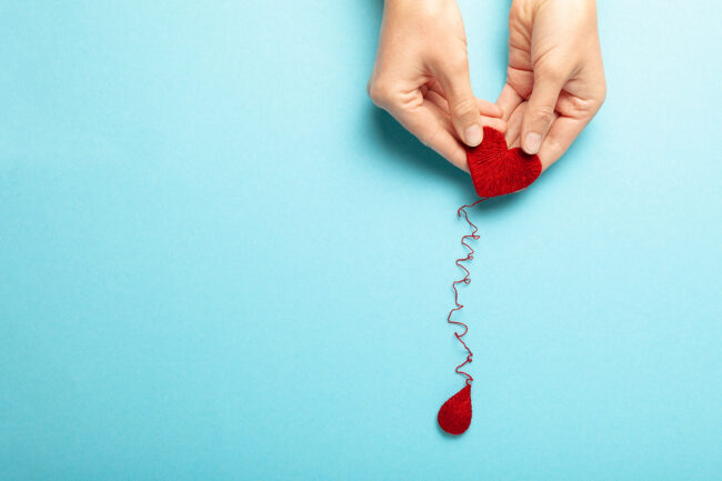 Blood donor. Hands with red heart and drop. Medical donation and